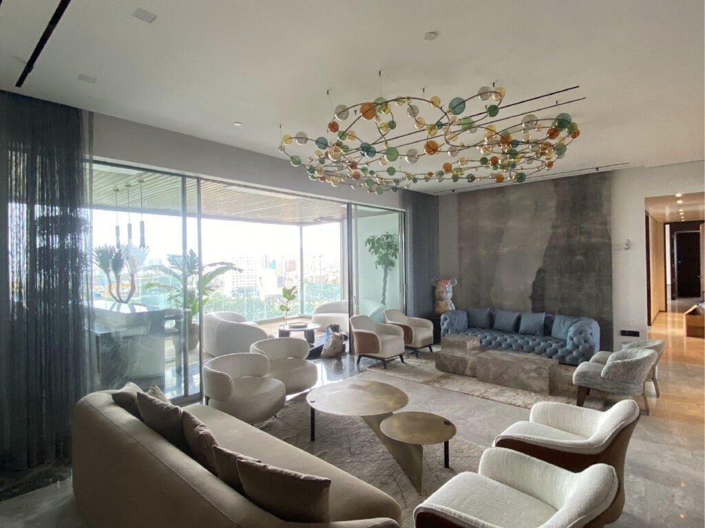 Living room of the Chhabra Residence in Mumbai with concealed in-ceiling speakers and a drop-down projector