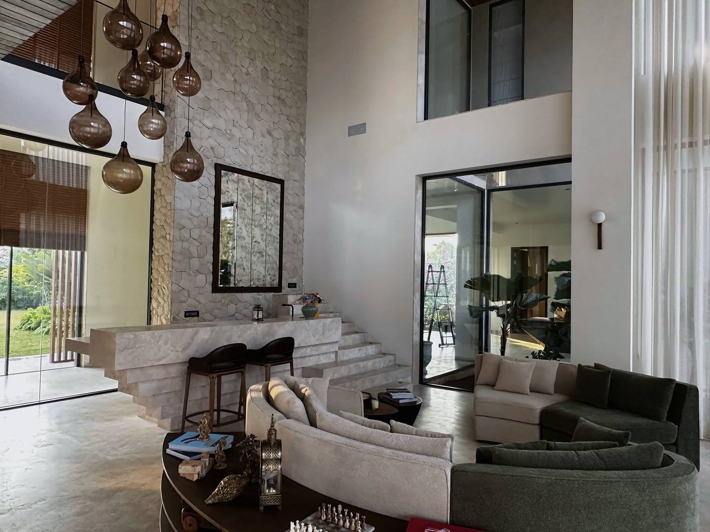 Double-height living room with stone wall in a private residence