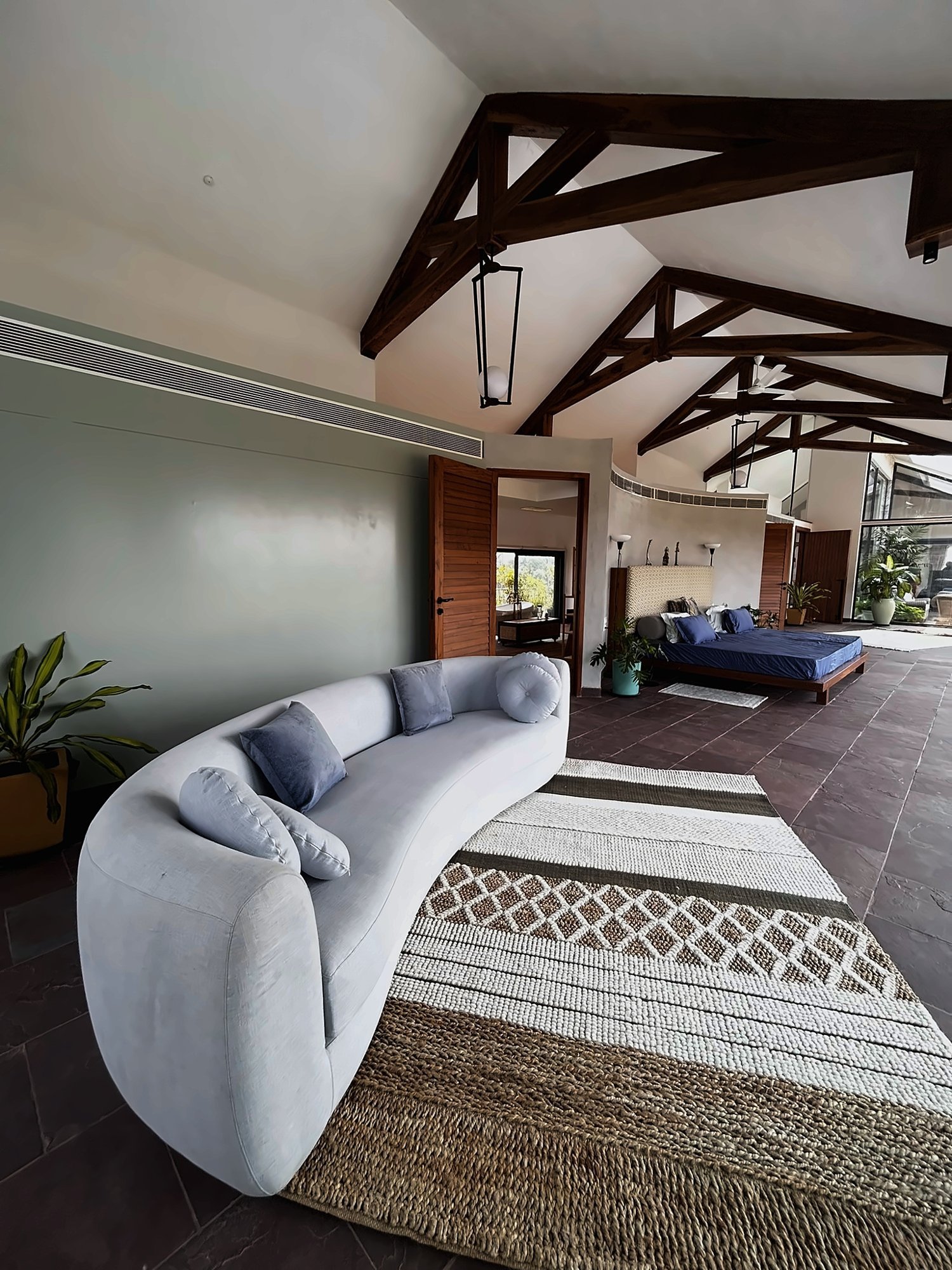 Living space under timber trusses with stone floor