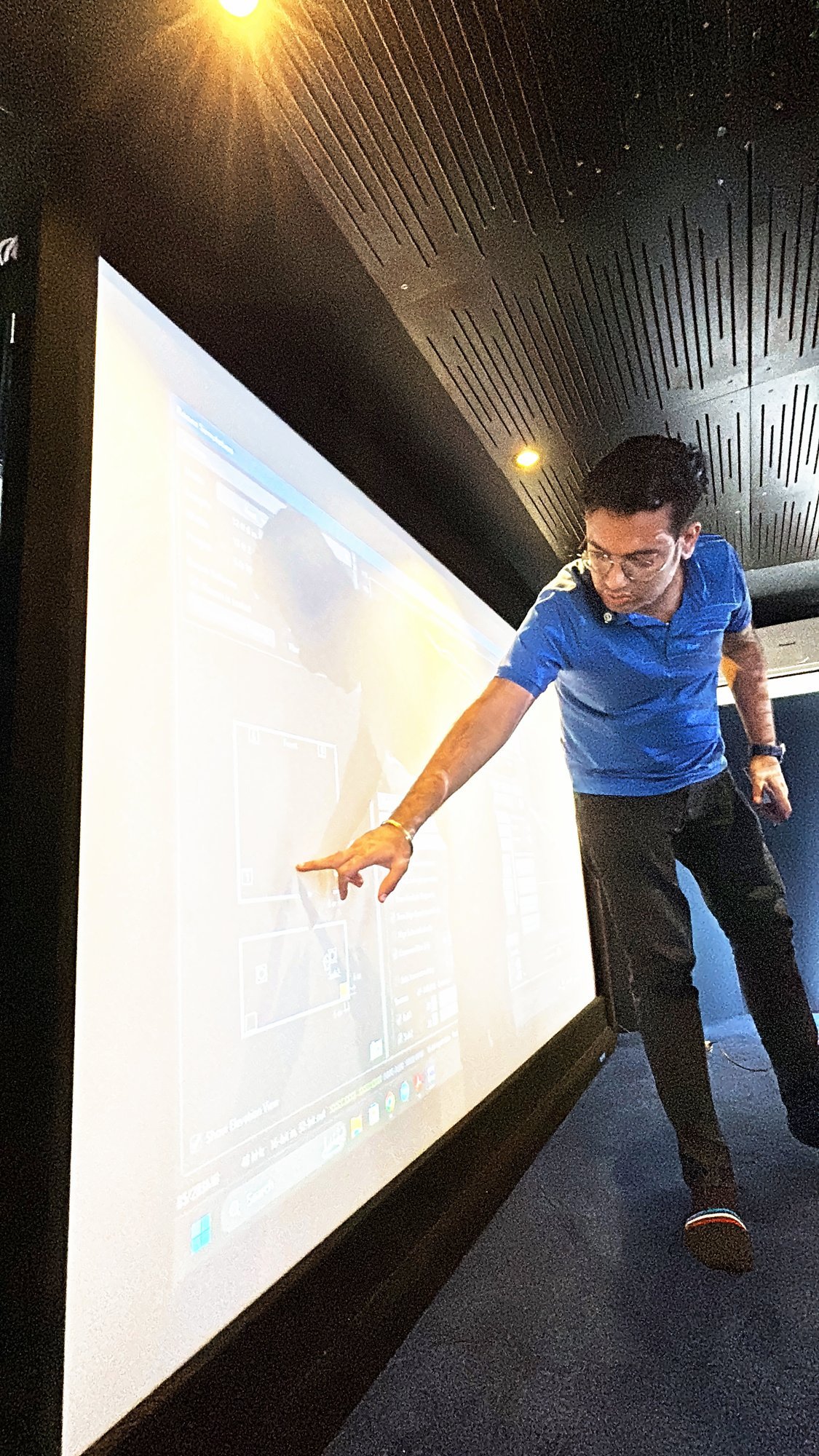 Trainer explaining the screen wall in a theatre room