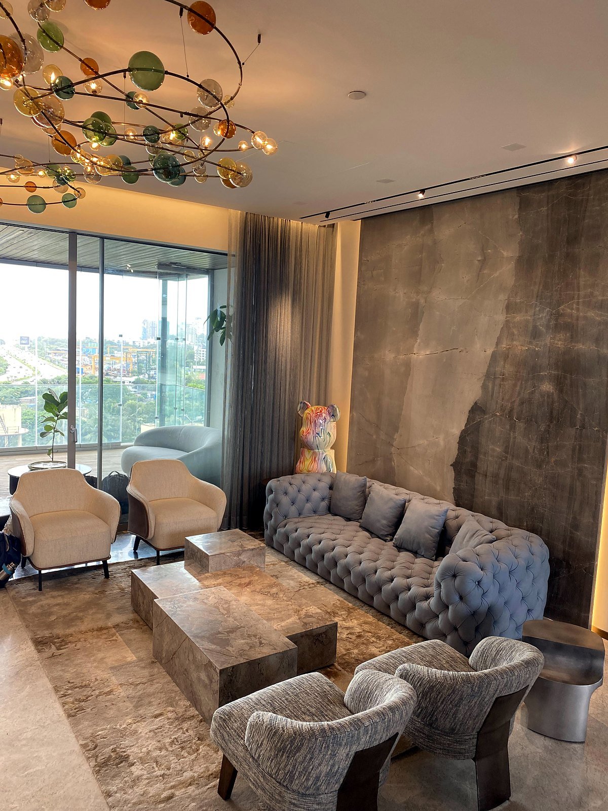 Living room of a smart apartment in Bandra, Mumbai, with sofas, chandelier and sea-facing windows