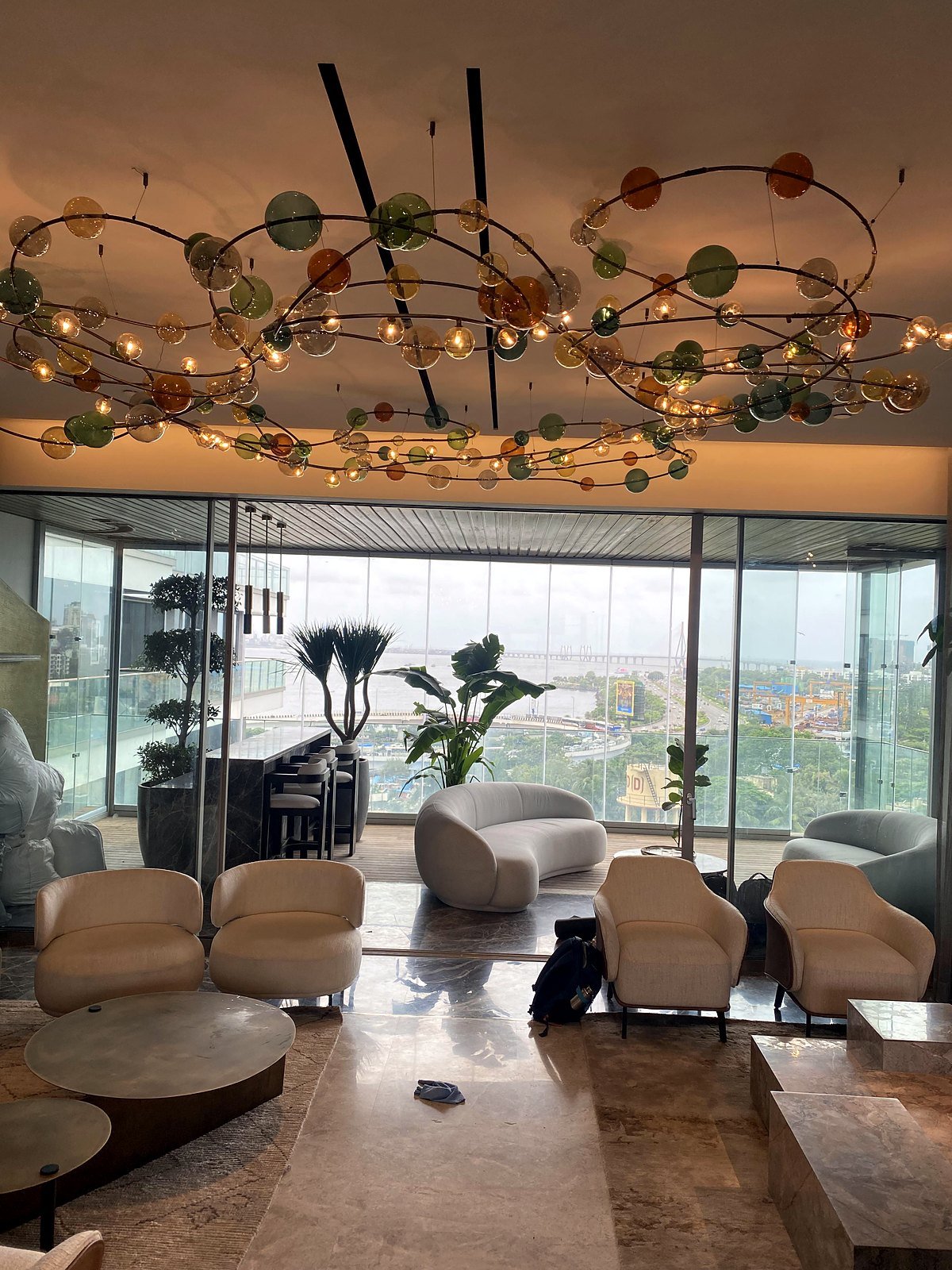 Living room of a Bandra apartment with a sea view and in-ceiling speakers, part of a two-zone music system