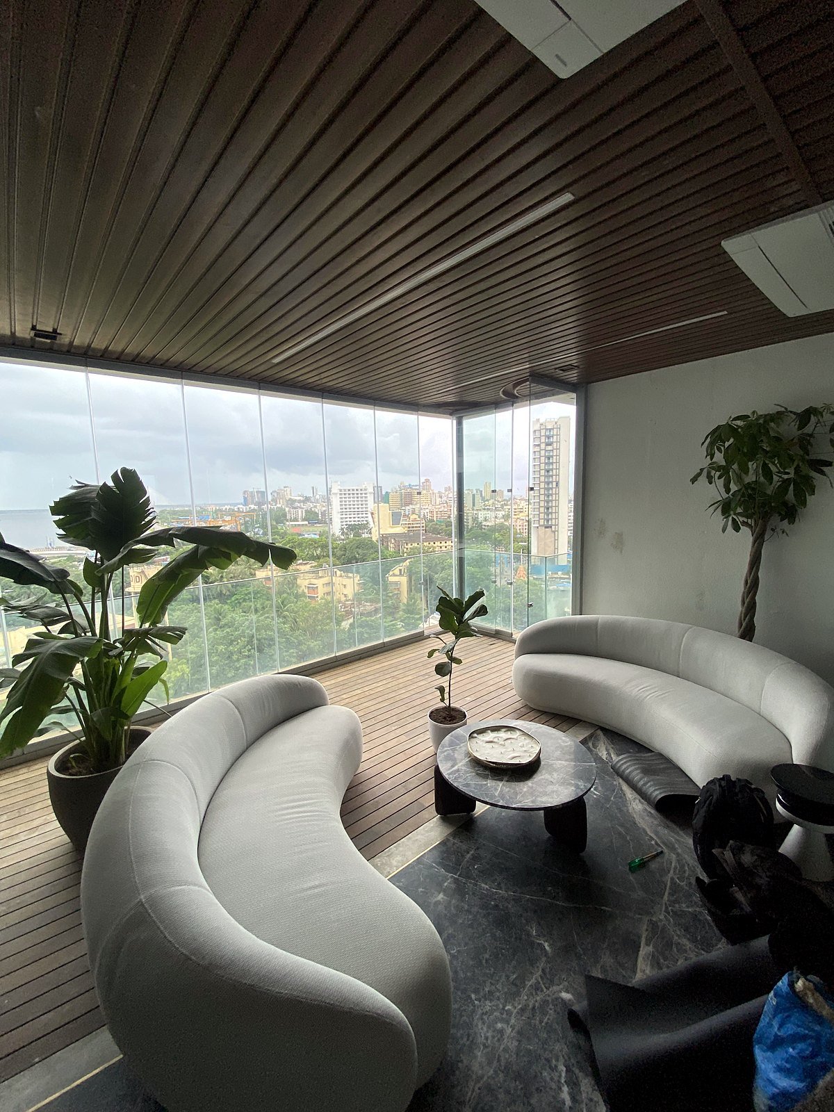 Corner of the living balcony in a Bandra smart apartment with panoramic glass