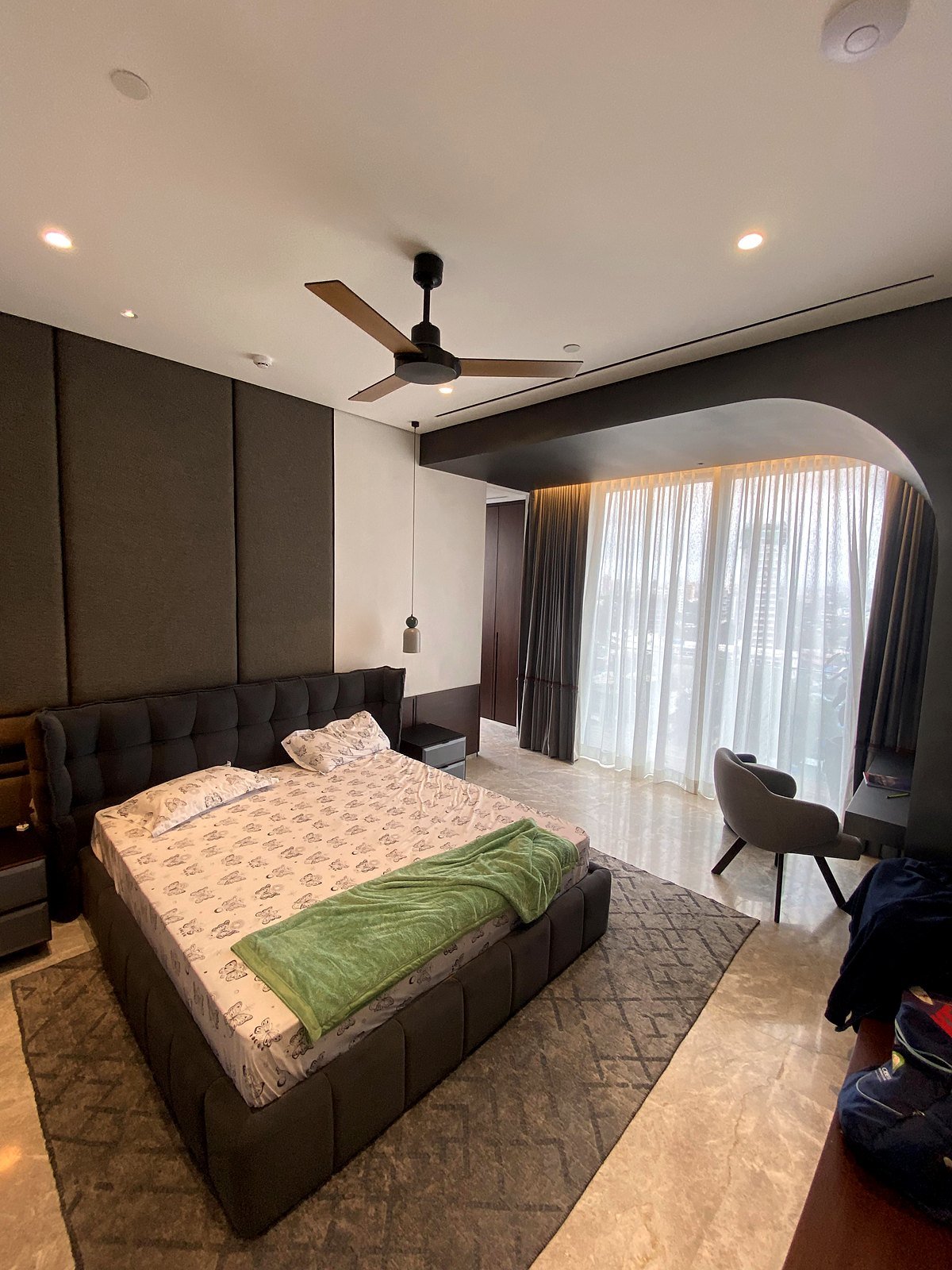 Bedroom with ceiling fan and curtains in a Bandra smart apartment