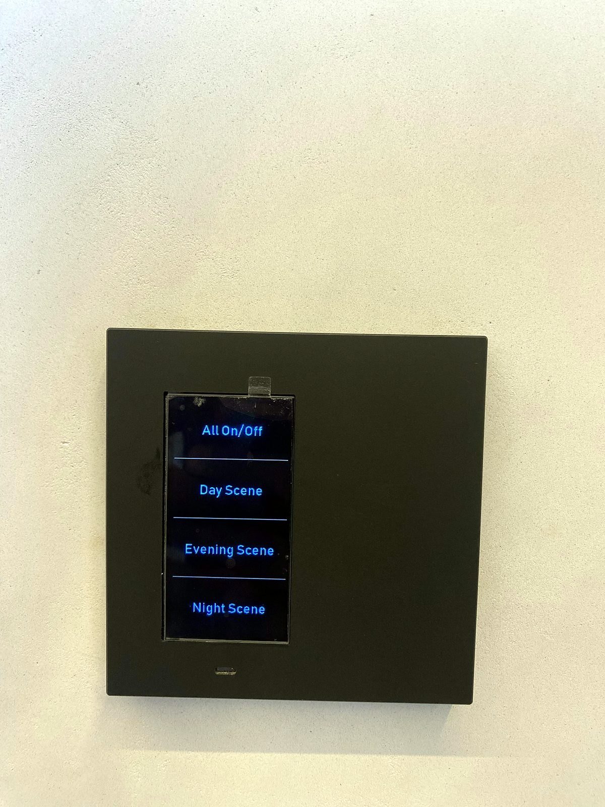 Black touch-display wall keypad in a Bandra smart apartment