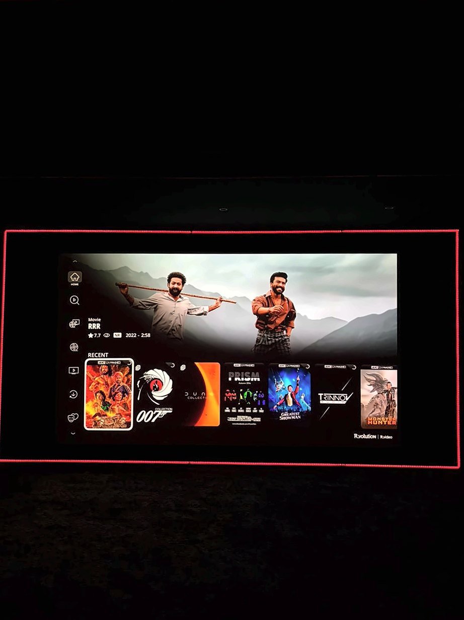 Large projection screen in the Devanahalli demo theatre showing a streaming menu