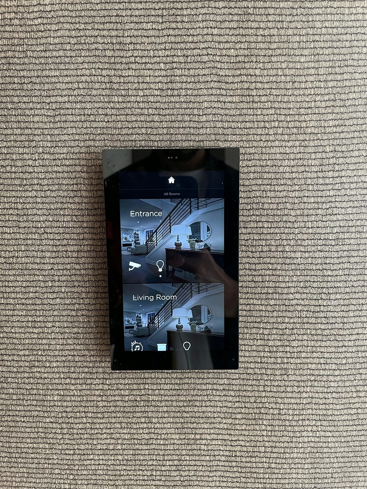 Wall touch screen at the entrance showing camera views and room controls