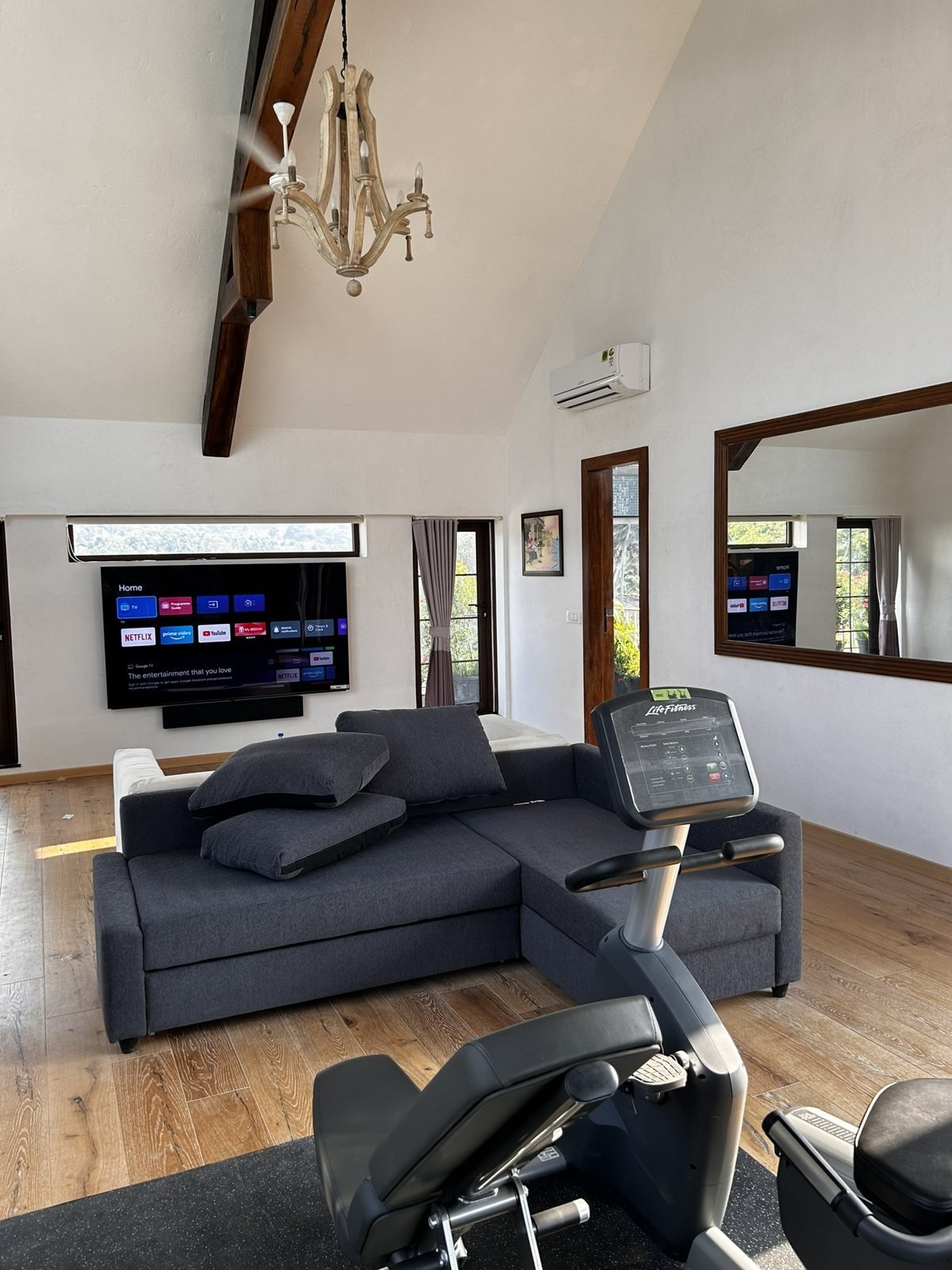 Wall-mounted 100-inch television with a Bang and Olufsen soundbar in a Goa villa living room