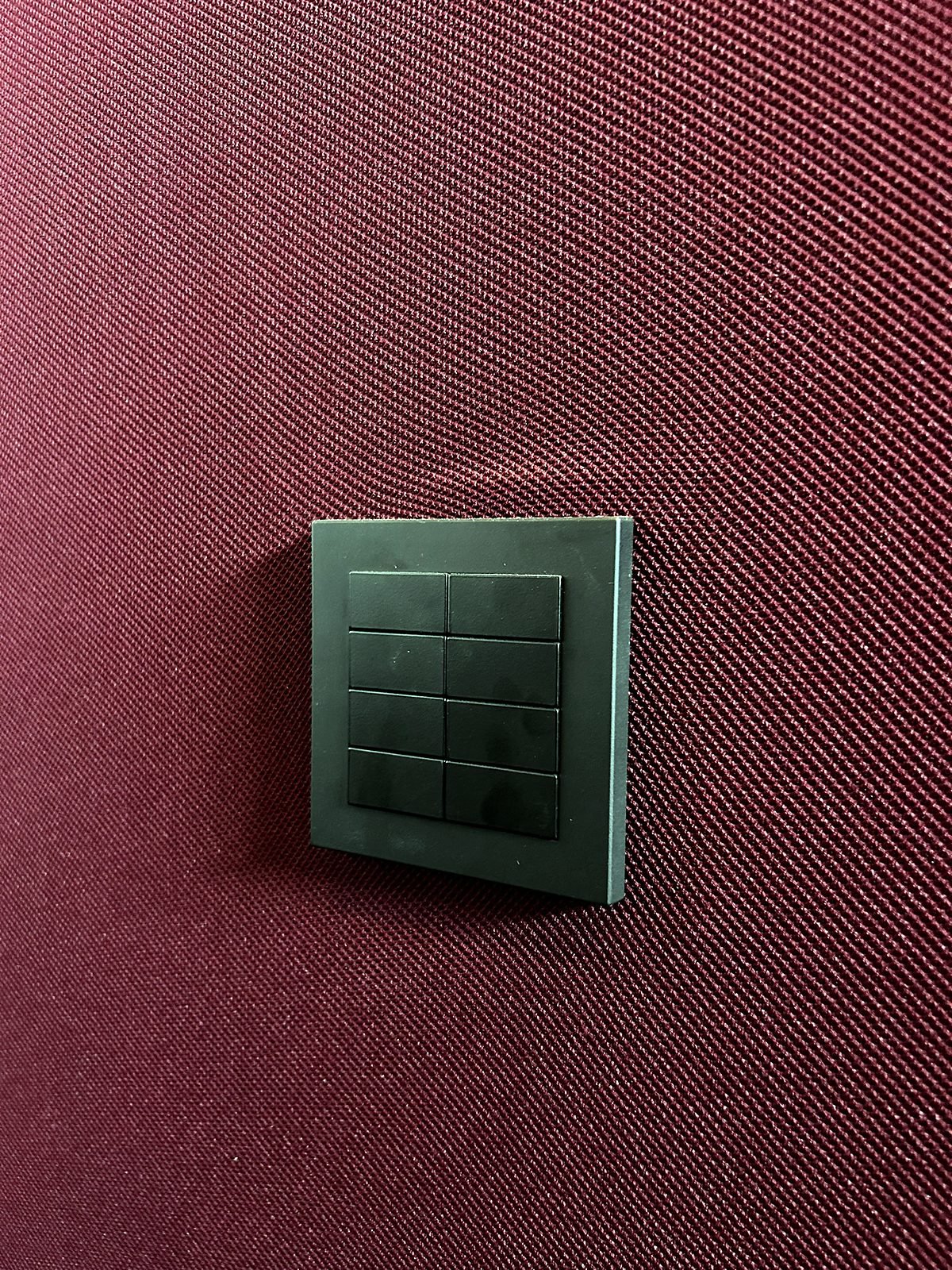 Wall keypad on an acoustic fabric wall in a Goa home theatre