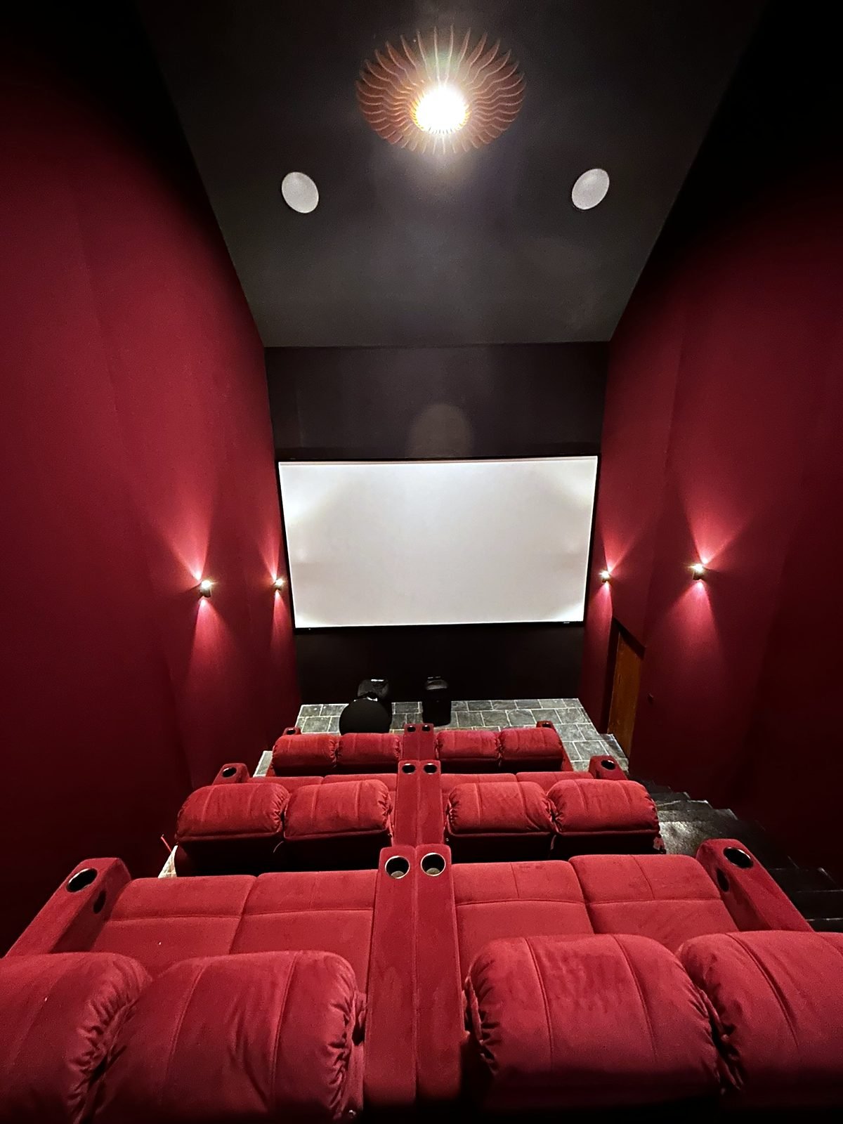 Home theatre seating rows with wall lighting in a Goa villa