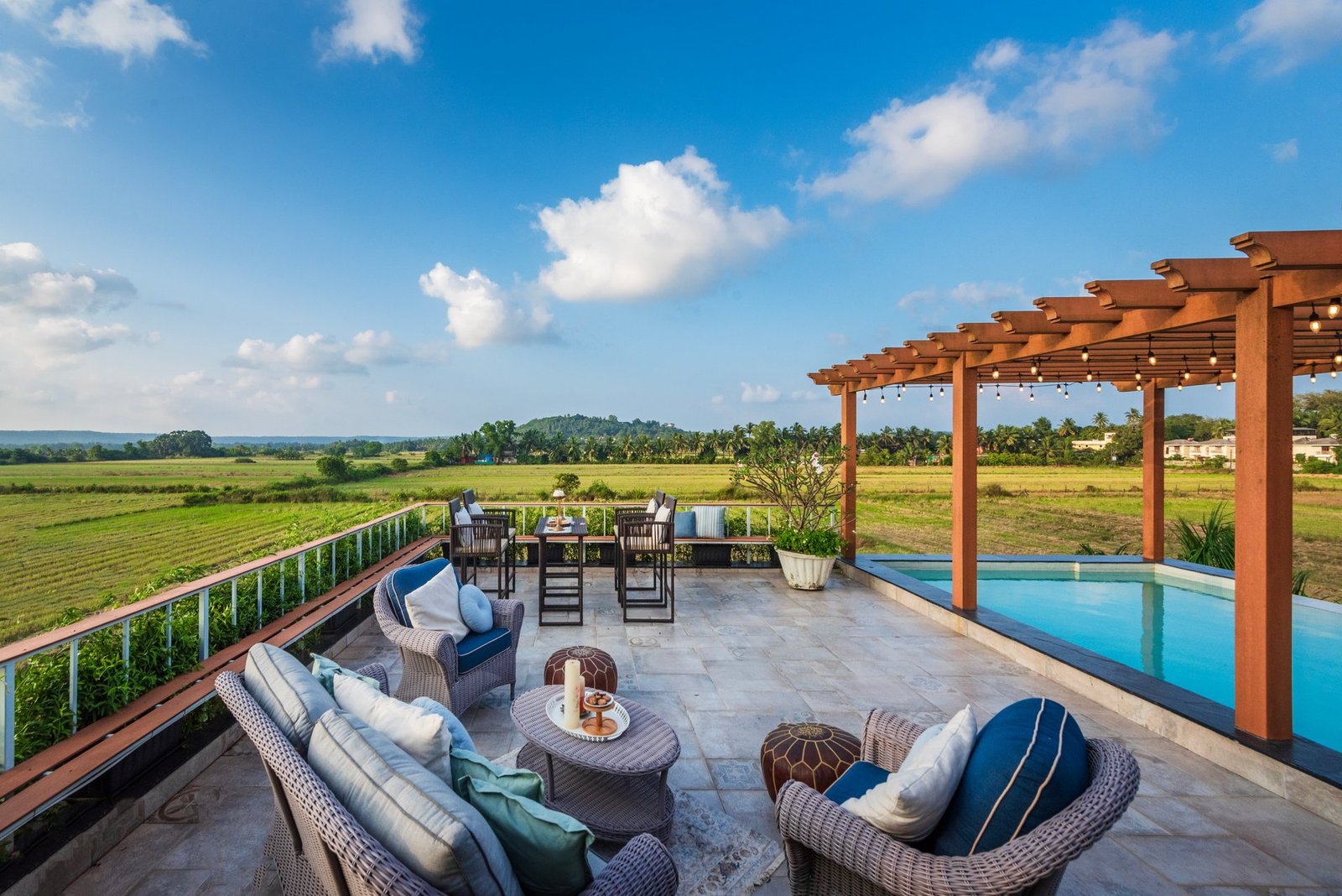 Pool-side lounge seating under a pergola in a Goa villa