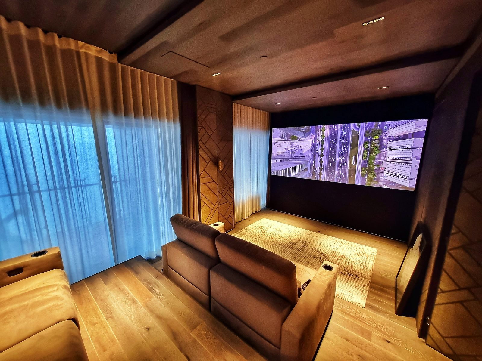 Dedicated home theatre with wood-panelled walls and recliner seating in a Lower Parel apartment