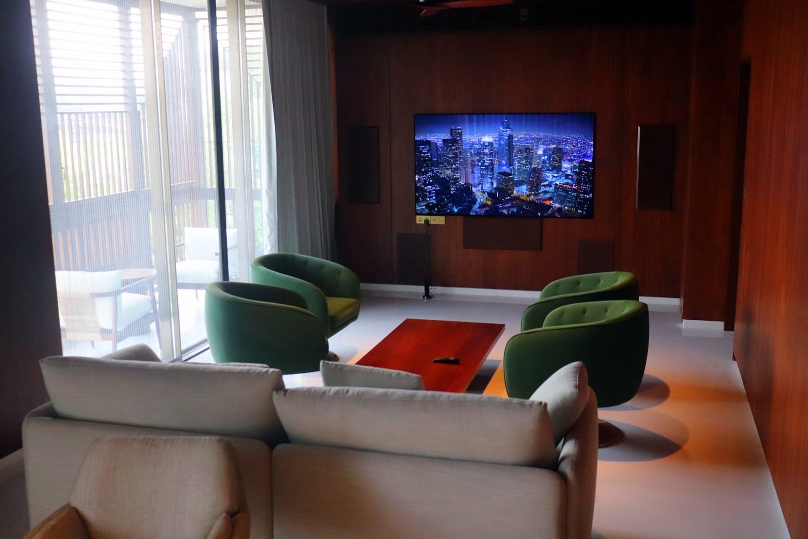 Wide lounge with white sofa and green armchairs in a six-storey Nagpur home