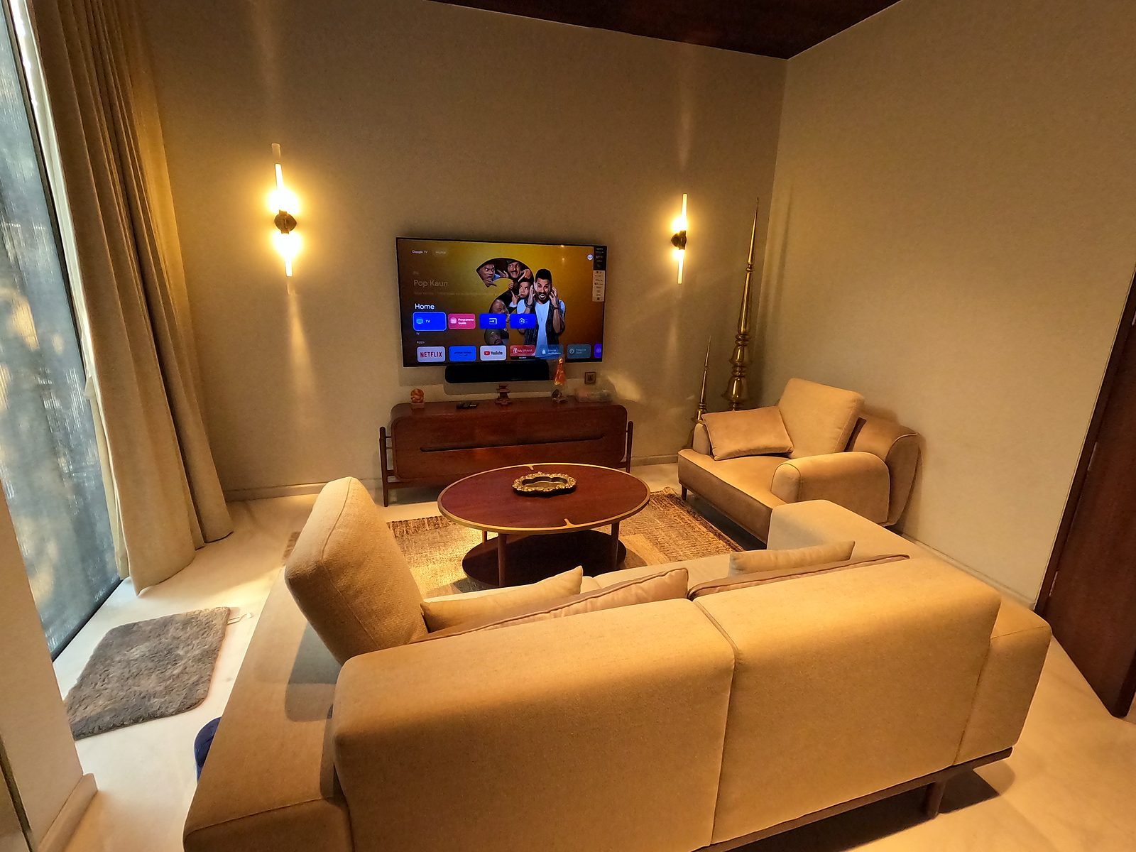 Living room with sofas and wall-mounted TV in a Nagpur smart home