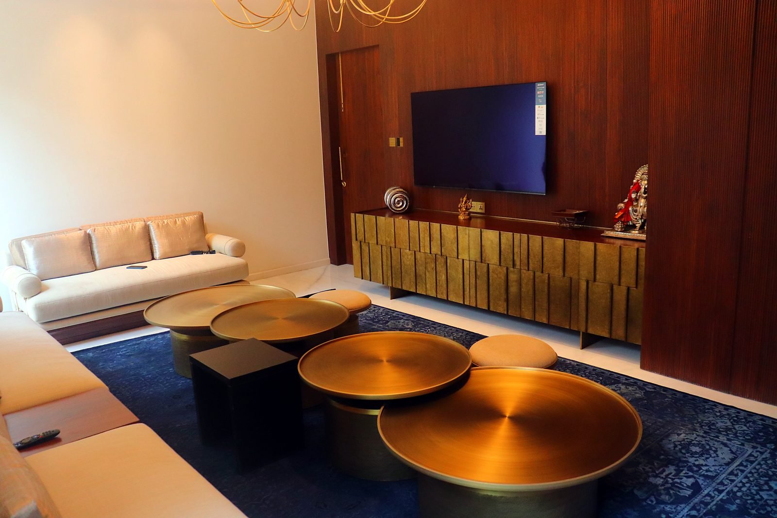 Living area with gold coffee tables and TV in a six-storey Nagpur mansion