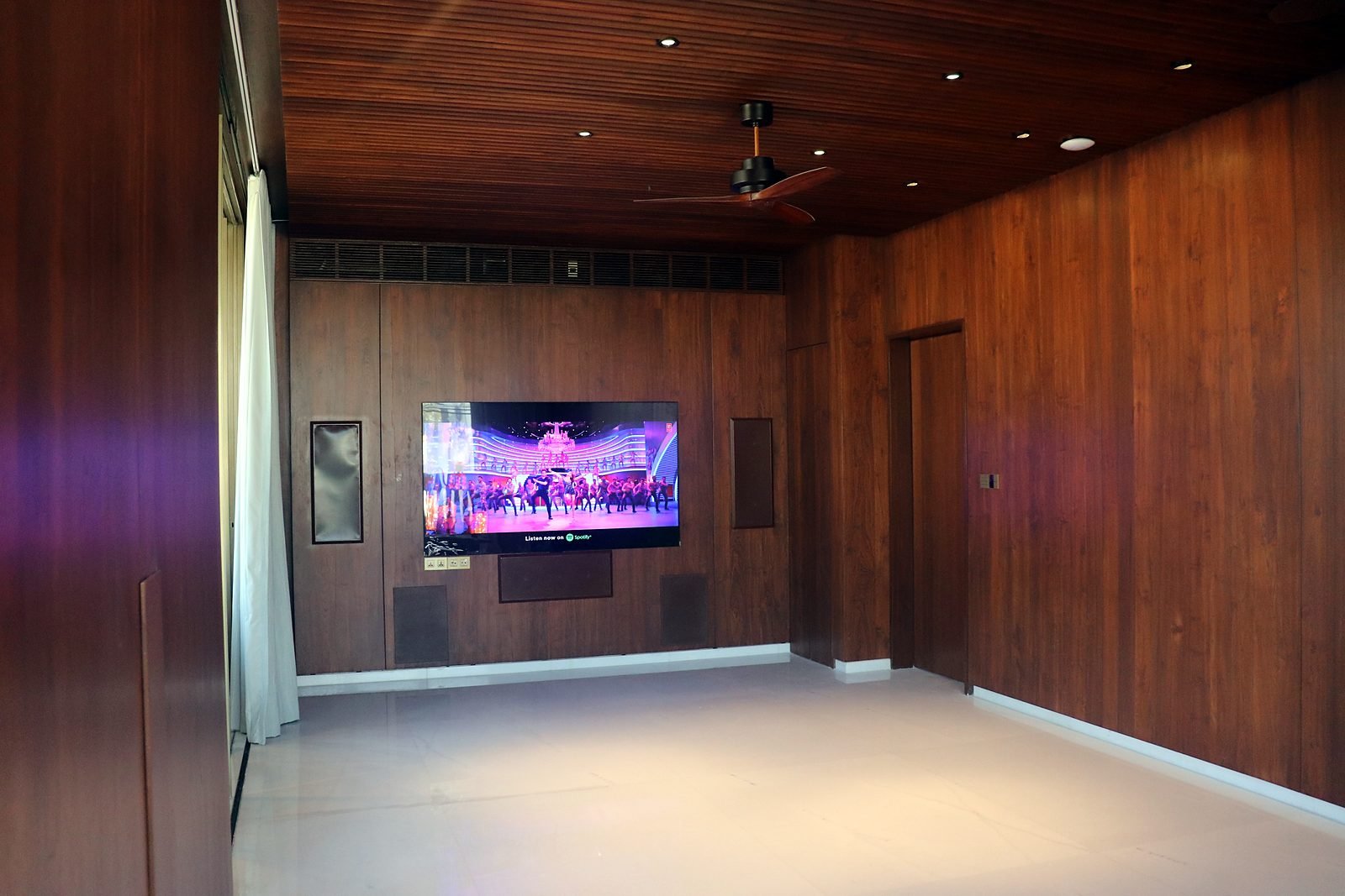 Wood-panelled TV room with in-wall speakers in a Nagpur smart mansion
