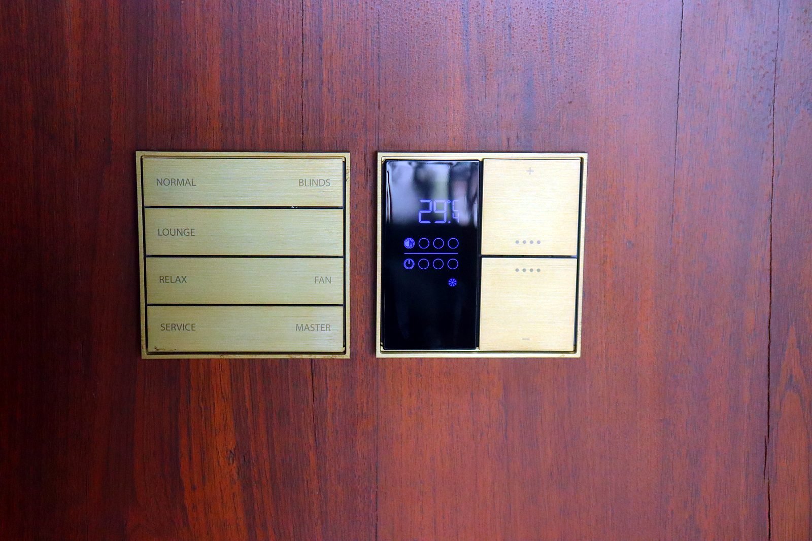 Brass-finish keypad and touch panel on a timber wall in a Nagpur smart home