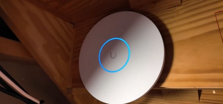 Ubiquiti UniFi ceiling access point with its blue status ring installed by Avenue Sound