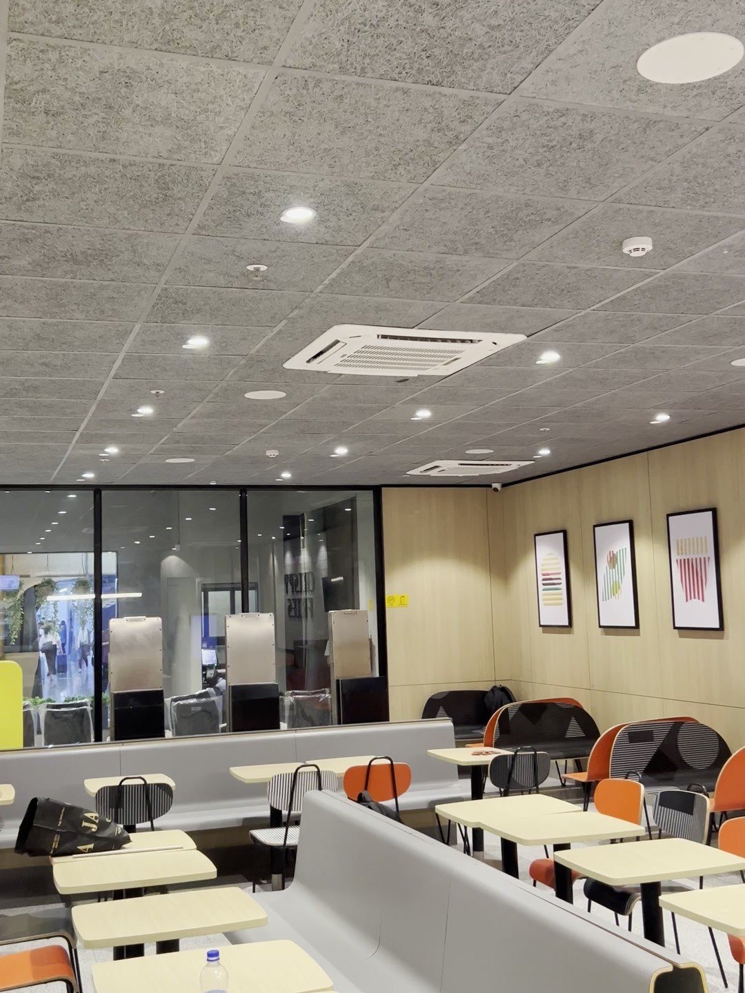 Dining area with flush ceiling speakers in the acoustic ceiling grid, in a restaurant for McDonald's India